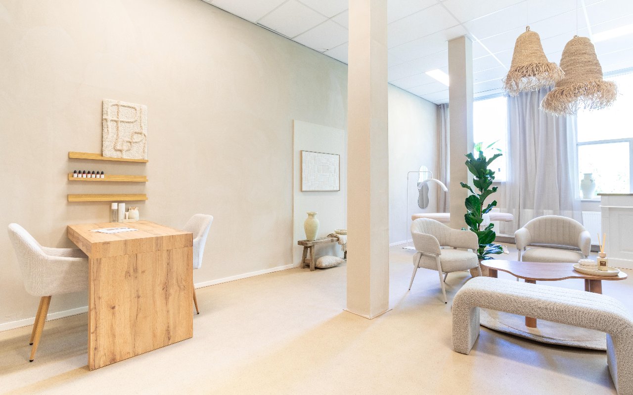 Houten tafel met wandkunst en de zithoek erachter