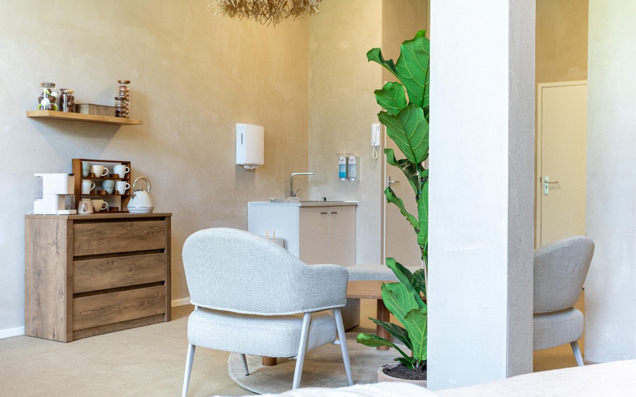 Fauteuil, eikenhouten kast met producten en de theehoek in de salon